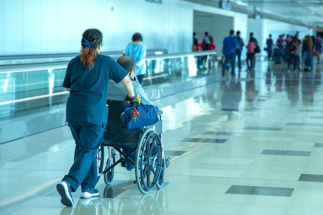 A medical escort providing wheelchair assistance