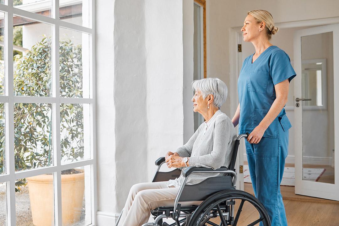 An elderly being assisted by a healthcare professional