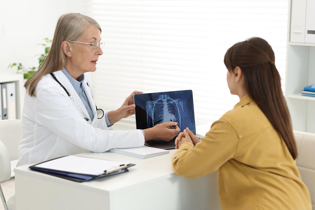 A doctor showing a patient an X-ray image of a lung condition